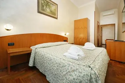 a bedroom with a bed with two towels on it at Hotel Corot in Rome