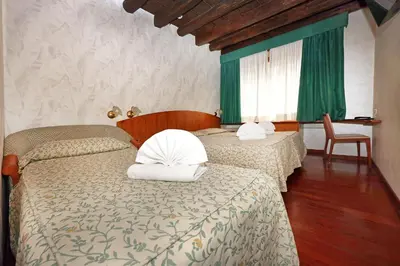 a bedroom with two beds with green curtains at Hotel Corot in Rome