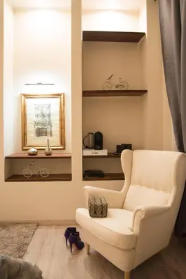 a living room with a white chair and a mirror at Town House 62 in Rome