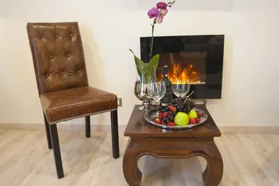a table with a bowl of fruit and a chair and a fireplace at Town House 62 in Rome
