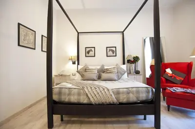 a bedroom with a canopy bed and a red chair at Town House 62 in Rome