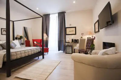 a bedroom with a bed and a living room with a couch at Town House 62 in Rome