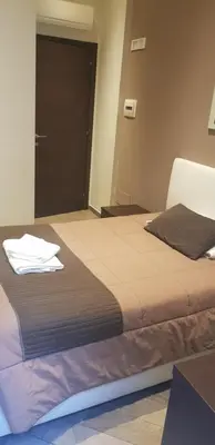 a bedroom with a bed and a door with towels on it at Mia Suites in Rome