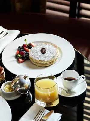 a table with a plate of pancakes and a cup of coffee at J.K. Place Roma - The Leading Hotels of the World in Rome