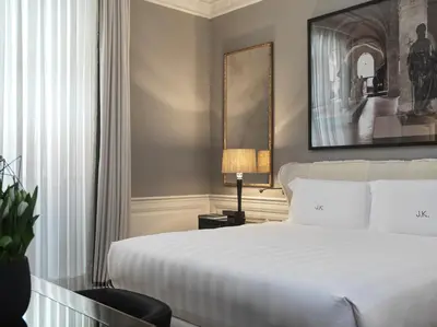 a bedroom with a large white bed and a lamp at J.K. Place Roma - The Leading Hotels of the World in Rome
