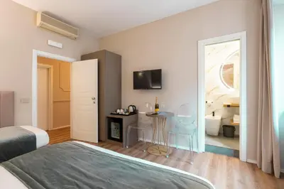a bedroom with a bed and a table and a room at Hotel Magic in Rome