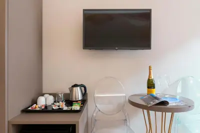 a room with a tv and a table with a bottle of wine at Hotel Magic in Rome
