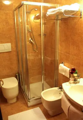 a bathroom with a shower and a toilet and a sink at Hotel Novecento in Rome