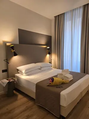 a bedroom with a large bed with a stuffed animal on it at Hotel Porta Pia in Rome