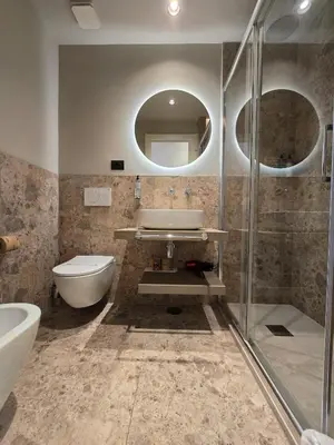 a bathroom with a sink and a toilet and a mirror at Hotel Porta Pia in Rome