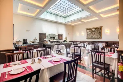 a dining room with tables and chairs and a skylight at Hotel Diocleziano in Rome