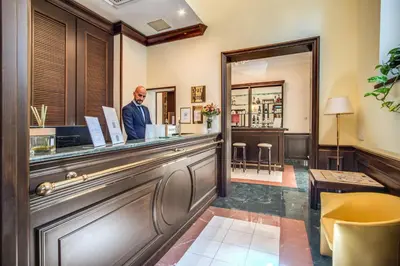 a man standing at the counter of a bar at Hotel Diocleziano in Rome
