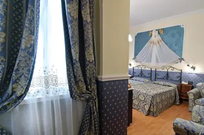a bedroom with a bed and a window with curtains at Residenza Antica Roma in Rome