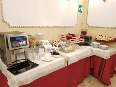 a table with a coffee maker and food on it at Hotel Villa Rosa in Rome