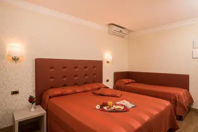 a hotel room with two beds with orange sheets at Hotel Villa Rosa in Rome
