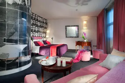 a living room with pink furniture and a bedroom at Hotel Abitart in Rome