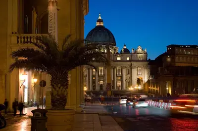 a building with a palm tree in front of a street at Palazzo Cardinal Cesi in Rome