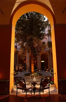 an archway with a table and chairs under a tree at Palazzo Cardinal Cesi in Rome