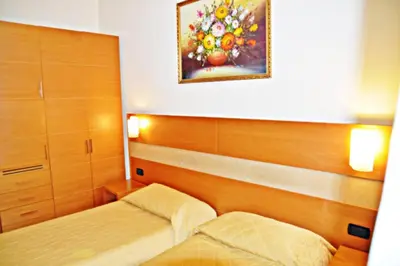 a bedroom with two beds and a painting on the wall at Hotel Moscatello in Rome