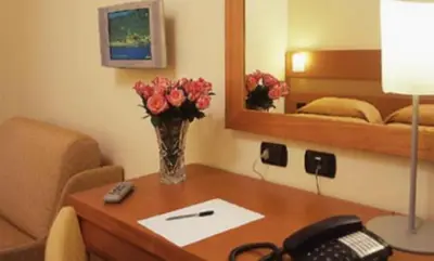 a room with a desk with a vase of flowers on it at Hotel Moscatello in Rome