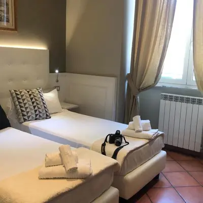 a hotel room with two beds with towels on them at 207 Inn in Rome