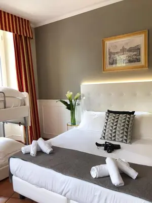 a bedroom with a white bed with two pairs of shoes on it at 207 Inn in Rome