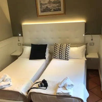 two beds with towels and a camera sitting on them at 207 Inn in Rome