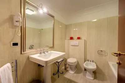a bathroom with a sink and a toilet and a mirror at Relais Hotel Antico Palazzo Rospigliosi in Rome