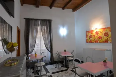a dining room with pink tables and chairs at Notti A Roma in Rome