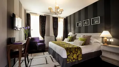 a bedroom with a large bed and a purple chair at The Inn at the Roman Forum Luxury Collection - The Inn At The Roman Forum in Rome