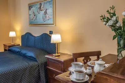 a hotel room with a bed and a table with cups on it at Hotel Caracciolo in Rome