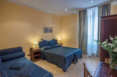 a hotel room with a bed and a couch at Hotel Caracciolo in Rome