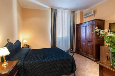 a hotel room with a bed and a couch and a window at Hotel Caracciolo in Rome