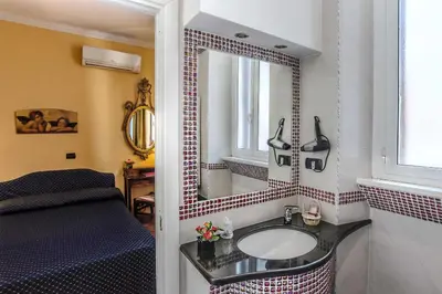 a bathroom with a sink and a mirror at Hotel Caracciolo in Rome
