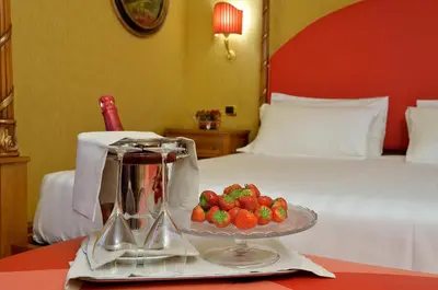 a tray of strawberries on a table next to a bed at Hotel Homs in Rome