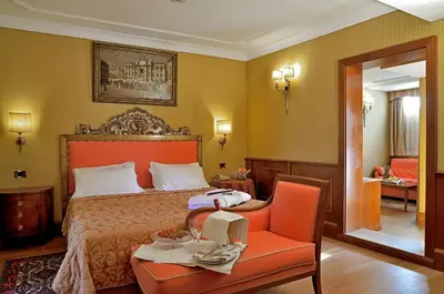 a bedroom with a bed and a table and a chair at Hotel Homs in Rome