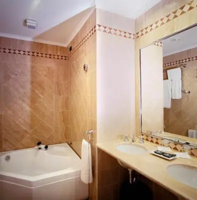 a bathroom with a tub and a sink and a mirror at Hotel Valle in Rome