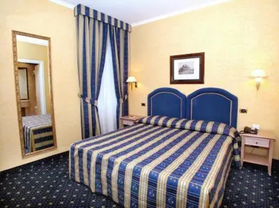 a hotel room with a blue bed and a mirror at Hotel Valle in Rome