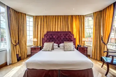 a bedroom with a large bed and windows at The Britannia Hotel in Rome