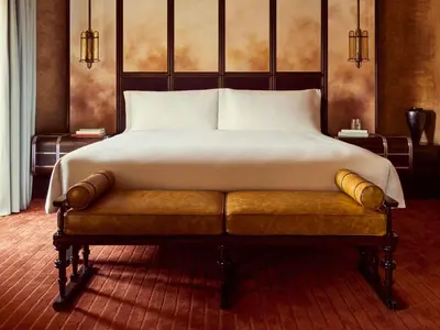 a bedroom with a bed and a chair and a window at Orient Express La Minerva in Rome