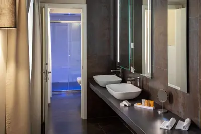 a bathroom with a sink and a mirror at Cosmopolita Rome Colosseum, Tapestry Collection by Hilton in Rome