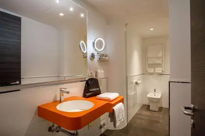 a bathroom with an orange sink and a toilet at Cosmopolita Rome Colosseum, Tapestry Collection by Hilton in Rome