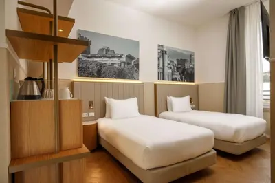a hotel room with two beds and a room with at Cosmopolita Rome Colosseum, Tapestry Collection by Hilton in Rome