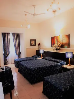 a hotel room with two beds and two tables at Hotel Sweet Home in Rome