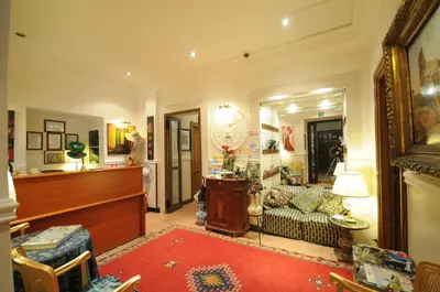 a living room with a couch and a mirror at Hotel Sweet Home in Rome