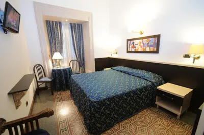 a hotel room with a bed and a table and chairs at Hotel Sweet Home in Rome