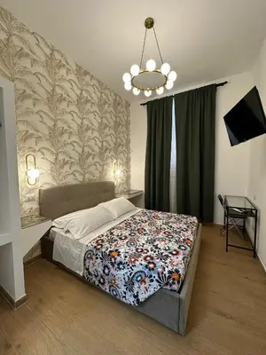a bedroom with a bed and a chandelier at Hotel Lodi in Rome