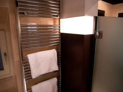 a bathroom with a towel rack with towels at Intown Luxury House in Rome