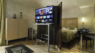 a hotel room with a bed and a flat screen tv at Intown Luxury House in Rome