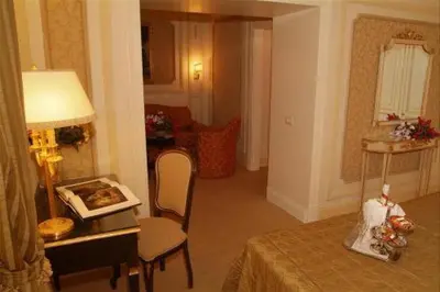 a living room with a table and a lamp and a room at Hotel Champagne Palace in Rome